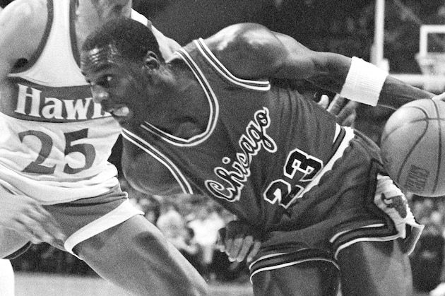 Chicago Bulls' Michael Jordan (23) drives past Atlanta Hawks' Glenn Rivers (25) during second period in their game at the Atlanta Omni, Jan. 3, 1985. Atlanta won the game 121-107. (AP Photo/Joe Holloway Jr.)