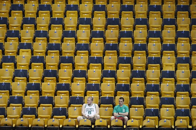 Two men sit amongst empty seats before a first-round NBA playoff basketball game between the Boston Celtics and the Chicago Bulls Sunday, April 16, 2017, in Boston. (AP Photo/Michael Dwyer)
