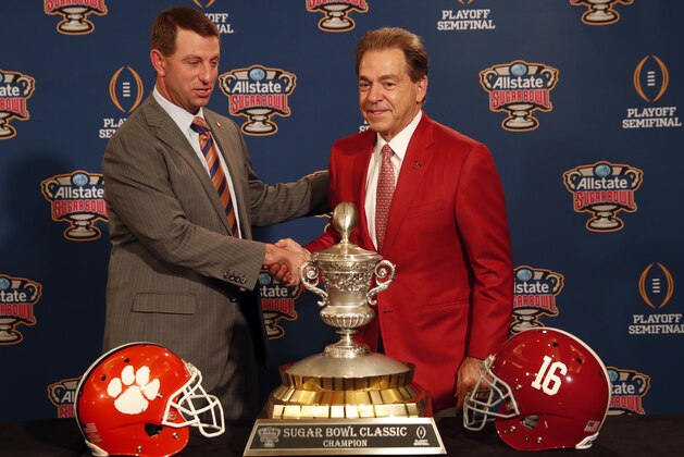 Clemson head coach Dabo Swinney and Alabama head coach Nick Saban, left, pose with the Sugar Bowl trophy for their upcoming semi-final playoff game, for the NCAA football national championship, in New Orleans, Sunday, Dec. 31, 2017. (AP Photo/Gerald Herbert)