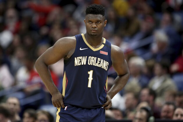 FILE - In this March 6, 2020, file photo, New Orleans Pelicans forward Zion Williamson walks onto the court during the second half of the team's NBA basketball game against the Miami Heat in New Orleans. The rookie sensation’s availability to play remained unclear as the season’s resumption in Lake Buena Vista, Florida, approached. He left the NBA’s so-called “bubble” setup on July 16 to attend to an unspecified family medical matter. A week later, the club had yet to provide an update on his possible return.  (AP Photo/Rusty Costanza, File)