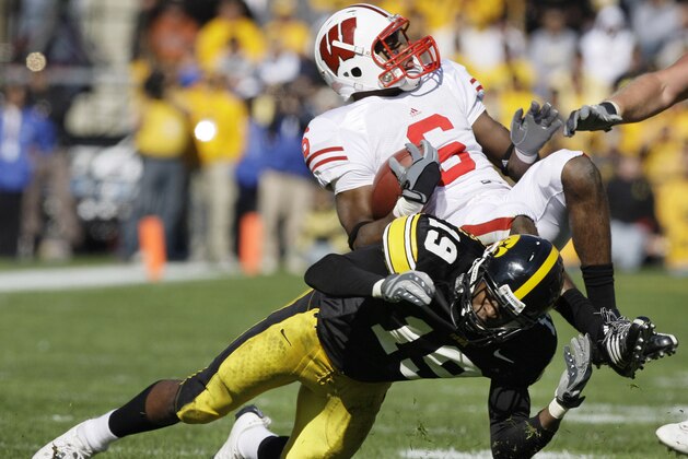Wisconsin's Isaac Anderson (6) is upended by Iowa's Amari Spievey (19) after catching a pass during the second half of an NCAA college football game, Saturday, Oct. 18, 2008, in Iowa City, Iowa. Iowa won 38-16. (AP Photo/Charlie Neibergall)