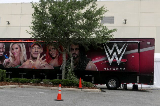 A trailer set up near a satellite truck to transmit wrestling broadcasts is parked outside the WWE Performance Center Tuesday, April 14, 2020, in Orlando, Fla. Florida’s top emergency official last week amended Gov. Ron DeSantis’ stay-at-home order to include employees at the professional sports and media production with a national audience, if the location is closed to the public.  (AP Photo/John Raoux)