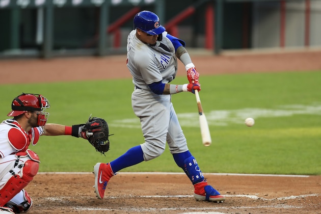 CORRECTS TO DOUBLE IN THE FIFTH INNING, INSTEAD OF HOME RUN IN THE SEVENTH INNING - Chicago Cubs' Javier Baez hits a double next to Cincinnati Reds catcher Curt Casali during the fifth inning of a baseball game in Cincinnati, Tuesday, July 28, 2020. (AP Photo/Aaron Doster)