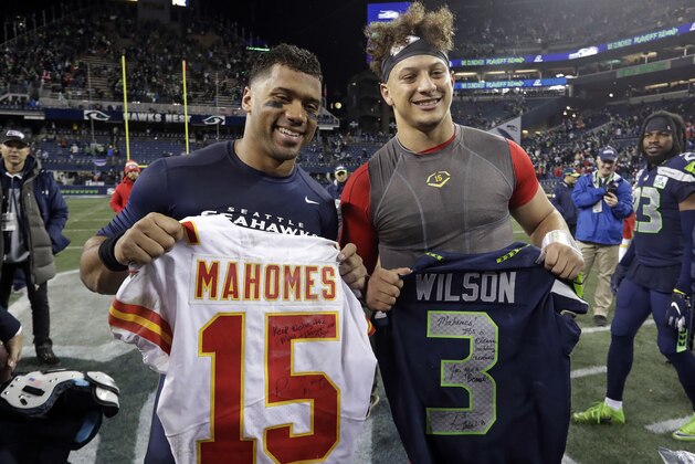 Seattle Seahawks quarterback Russell Wilson, left, and Kansas City Chiefs quarterback Patrick Mahomes pose for a photo after they swapped jerseys after an NFL football game, Sunday, Dec. 23, 2018, in Seattle. The Seahawks won 38-31. (AP Photo/Elaine Thompson)