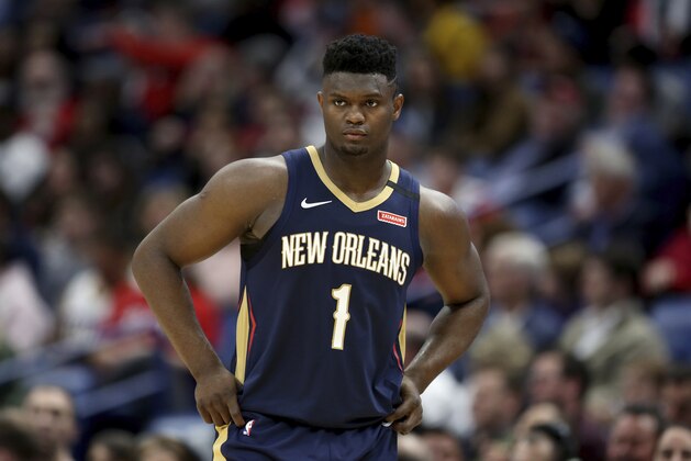 FILE - In this March 6, 2020, file photo, New Orleans Pelicans forward Zion Williamson walks onto the court during the second half of the team's NBA basketball game against the Miami Heat in New Orleans. The rookie sensation’s availability to play remained unclear as the season’s resumption in Lake Buena Vista, Florida, approached. He left the NBA’s so-called “bubble” setup on July 16 to attend to an unspecified family medical matter. A week later, the club had yet to provide an update on his possible return.  (AP Photo/Rusty Costanza, File)