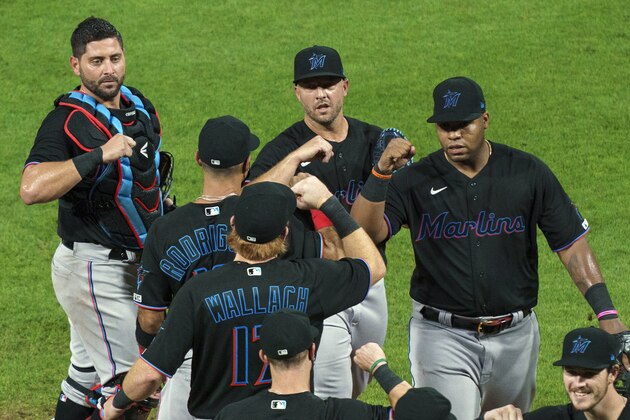 FILE - In this Friday, July 24, 2020, file photo, Miami Marlins' Jesus Aguilar, right, celebrates a 5-2 win with teammates following a baseball game against the Philadelphia Phillies in Philadelphia. The Marlinsâ€™ coronavirus outbreak could endanger the Major League Baseball season, Dr. Anthony Fauci said, as the number of their players testing positive rose to 15. The Marlins received positive test results for four additional players Tuesday, July 23, 2020, a person familiar with the situation told The Associated Press. (AP Photo/Chris Szagola, File)