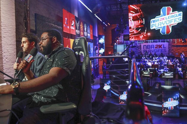 Jeff Eisenband, left, and Phil Eisu, right, live broadcast live day one of the NBA 2k League (NBA2KL) professional esports playoffs, Wednesday, July 24, 2019, in Queens borough of New York. The teams kicked off day one of the NBA2KL playoffs with Blazers on the losing 67-45. (AP Photo/Bebeto Matthews)