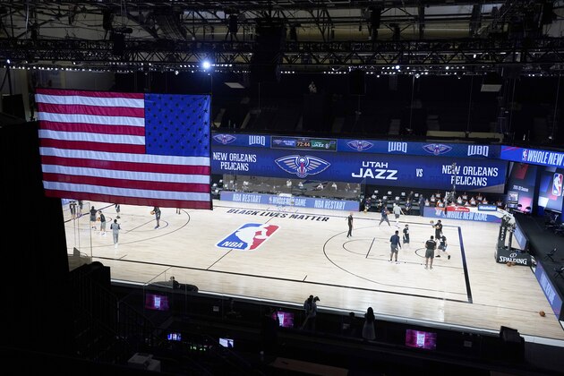 Members of the New Orleans Pelicans and Utah Jazz warm up before the start of an NBA basketball game with no fans in the stands as seen in this general view Thursday, July 30, 2020, in Lake Buena Vista, Fla. (AP Photo/Ashley Landis, Pool)