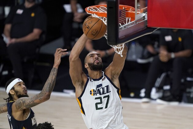 Utah Jazz's Rudy Gobert (27) heads to the basket past New Orleans Pelicans' Brandon Ingram, left, during the second half of an NBA basketball game Thursday, July 30, 2020, in Lake Buena Vista, Fla. (AP Photo/Ashley Landis, Pool)