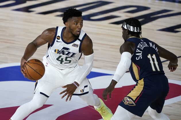 Utah Jazz's Donovan Mitchell (45) heads to the basket past New Orleans Pelicans' Jrue Holiday (11) during the second half of an NBA basketball game Thursday, July 30, 2020, in Lake Buena Vista, Fla. (AP Photo/Ashley Landis, Pool)
