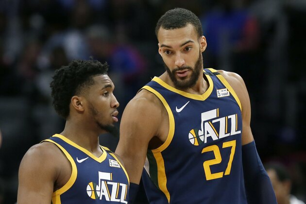 FILE - In this Saturday, March 7, 2020, file photo, Utah Jazz center Rudy Gobert (27) talks with guard Donovan Mitchell, left, during the second half of an NBA basketball game against the Detroit Pistons, in Detroit. Both players have tested positive for the coronavirus.  Gobert's test result forced the NBA to suspend the season. (AP Photo/Duane Burleson, File)