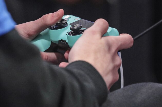 A contestant toggles a game controller during day one of the NBA 2k League (NBA2KL) professional esports playoffs, Wednesday, July 24, 2019, in Queens borough of New York. (AP Photo/Bebeto Matthews)