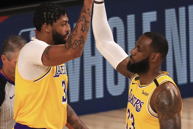 Los Angeles Lakers Anthony Davis (3) and LeBron James (23) high-five during the first quarter of an NBA basketball game against the Los Angeles Clippers, Thursday, July 30, 2020, in Lake Buena Vista, Fla. (Mike Ehrmann/Pool Photo via AP)