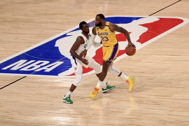 Los Angeles Lakers' LeBron James (23) dribbles the ball against Los Angeles Clippers' Reggie Jackson during the first quarter of an NBA basketball game Thursday, July 30, 2020, in Lake Buena Vista, Fla. (Mike Ehrmann/Pool Photo via AP)