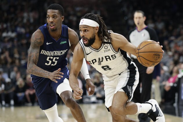 San Antonio Spurs guard Patty Mills (8) drives around Dallas Mavericks guard Delon Wright (55) during the second half of an NBA basketball game in San Antonio, Tuesday, March 10, 2020. (AP Photo/Eric Gay)
