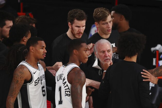 San Antonio Spurs head coach Gregg Popovich talks to his players in a huddle in the first half of an NBA basketball game against the Sacramento Kings, Friday, July 31, 2020, in Lake Buena Vista, Fla. (Kim Klement/Pool Photo via AP)