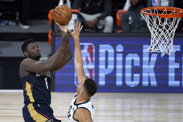 New Orleans Pelicans' Zion Williamson, left, shoots over Utah Jazz's Georges Niang during the first half of an NBA basketball game Thursday, July 30, 2020, in Lake Buena Vista, Fla. (AP Photo/Ashley Landis, Pool)