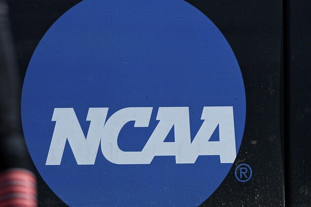 FILE - In this April 19, 2019, file photo, an athlete stands near a NCAA logo during a softball game in Beaumont, Texas. California will let college athletes hire agents and make money from endorsements, defying the NCAA and setting up a likely legal challenge that could reshape U.S. amateur sports. (AP Photo/Aaron M. Sprecher, File) FILE - In this April 19, 2019, file photo, an athlete stands near a NCAA logo during a softball game in Beaumont, Texas. California will let college athletes hire agents and make money from endorsements, defying the NCAA and setting up a likely legal challenge that could reshape U.S. amateur sports. (AP Photo/Aaron M. Sprecher, File)