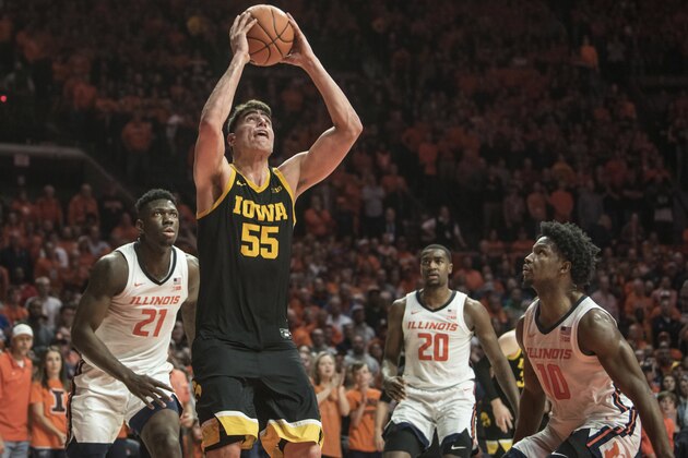 Iowa's Luka Garza (55) shoots as Illinois' Kofi Cockburn (21), Da'Monte Williams (20), and Andres Feliz (10) defend in the second half of an NCAA college basketball game Sunday, March 8, 2020, in Champaign, Ill. (AP Photo/Holly Hart)