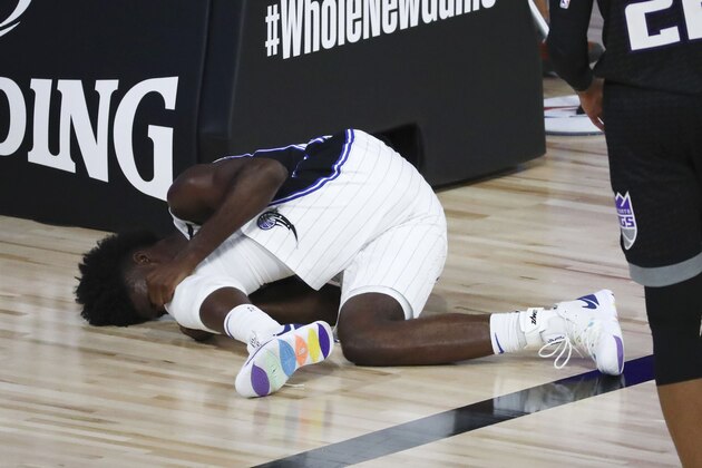 Orlando Magic forward Jonathan Isaac lies on the court after an injury during the second half of the team's NBA basketball game against the Sacramento Kings on Sunday, Aug. 2, 2020, in Lake Buena Vista, Fla. (Kim Klement/Pool Photo via AP)