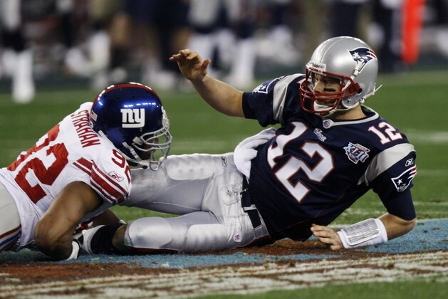New England Patriots quarterback Tom Brady (12) is knocked down by New York Giants defensive end Michael Strahan (92) in the first quarter of the the Super Bowl XLII football game at University of Phoenix Stadium on Sunday, Feb. 3, 2008 in Glendale, Ariz. (AP Photo/Julie Jacobson)