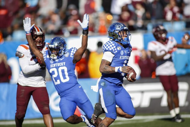 Kentucky quarterback Lynn Bowden Jr. (1) rushes for a 61-yard touchdown against Virginia Tech as Kentucky running back Kavosiey Smoke (20) celebrates in front of Virginia Tech linebacker Rayshard Ashby (23) in the second half of the Belk Bowl NCAA college football game in Charlotte, N.C., Tuesday, Dec. 31, 2019. Kentucky won 37-30. (AP Photo/Nell Redmond)