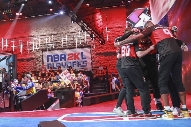 Team members of Blazers Gaming, an NBA 2k League (NBA2KL) professional esports team, huddle before taking seats at their video stations for a match against Warriors Gaming Squad, Wednesday, July 24, 2019, in Queens borough of New York. The teams kicked off day one of the NBA2KL playoffs with Blazers on the losing 67-45. (AP Photo/Bebeto Matthews) Team members of Blazers Gaming, an NBA 2k League (NBA2KL) professional esports team, huddle before taking seats at their video stations for a match against Warriors Gaming Squad, Wednesday, July 24, 2019, in Queens borough of New York. The teams kicked off day one of the NBA2KL playoffs with Blazers on the losing 67-45. (AP Photo/Bebeto Matthews)