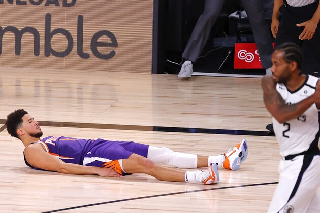 Phoenix Suns' Devin Booker falls to the ground after scoring the game-winning basket against the Los Angeles Clippers in an NBA basketball game Tuesday, Aug. 4, 2020, in Lake Buena Vista, Fla. (Kevin C. Cox/Pool Photo via AP)