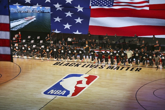 Members of the Boston Celtics and the Miami Heat kneel during the national anthem before an NBA basketball game Tuesday, Aug. 4, 2020, in Lake Buena Vista, Fla. (Kim Klement/Pool Photo via AP)