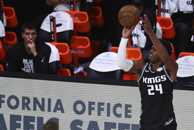 Sacramento Kings guard Buddy Hield (24) shoots a 3-point basket against Dallas Mavericks forward Kristaps Porzingis (6) during the first half of an NBA basketball game Tuesday, Aug. 4, 2020, in Lake Buena Vista, Fla. (Kim Klement/Pool Photo via AP)