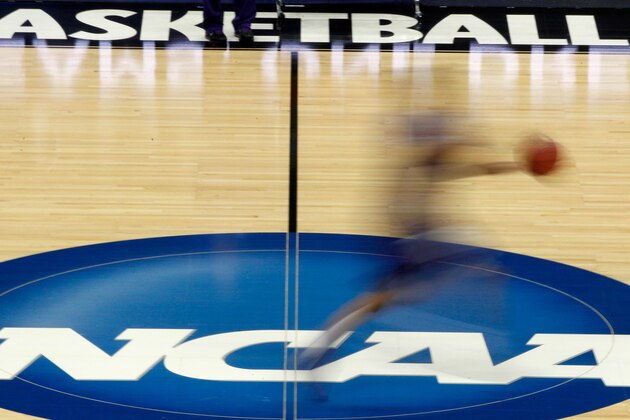 FILE - In this March 14, 2012, file photo, a player runs across the NCAA logo during practice in Pittsburgh before an NCAA tournament college basketball game. The number of teams facing postseason bans because of low scores on the NCAA's Academic Progress Rate has nearly doubled in one year. Fifteen teams could face the most severe sanction next season compared with eight in 2019-20. (AP Photo/Keith Srakocic, File)