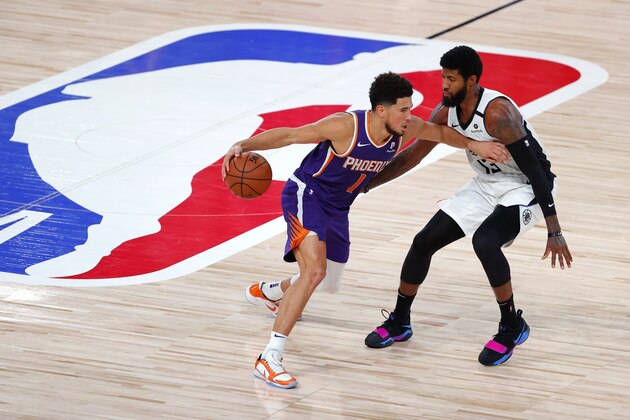 Los Angeles Clippers' Paul George defends against Phoenix Suns' Devin Booker (1) during an NBA basketball game Tuesday, Aug. 4, 2020, in Lake Buena Vista, Fla. (Kevin C. Cox/Pool Photo via AP)