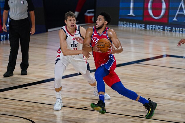 Philadelphia 76ers guard Ben Simmons (25) drives on Washington Wizards forward Moritz Wagner (21) during the first half of an NBA basketball game Wednesday, Aug. 5, 2020 in Lake Buena Vista, Fla. (AP Photo/Ashley Landis)