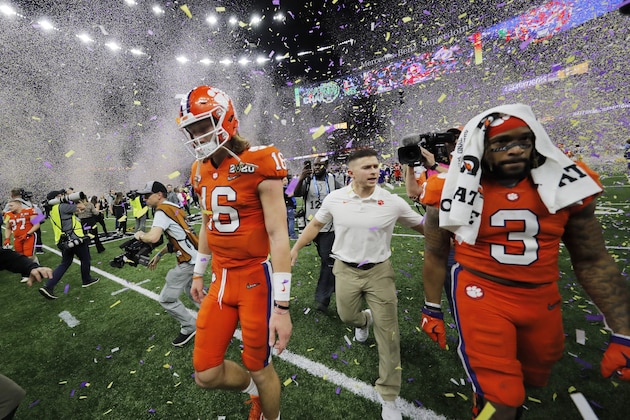 Clemson quarterback Trevor Lawrence, left, leaves the field after a NCAA College Football Playoff national championship game against LSU, Monday, Jan. 13, 2020, in New Orleans. LSU won 42-25.(AP Photo/Gerald Herbert)