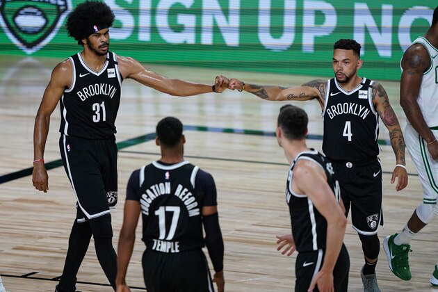 Brooklyn Nets center Jarrett Allen (31) and guard Chris Chiozza (4) bump fists during the first half of an NBA basketball game against the Boston Celtics Wednesday, Aug. 5, 2020 in Lake Buena Vista, Fla. (AP Photo/Ashley Landis)