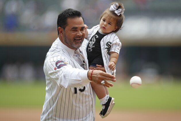 Former Chicago White Sox manager Ozzie Guillen throws out a ceremonial pitch with his granddaughter Adela before the start of a baseball game Sunday, July 7, 2019, in Chicago. (AP Photo/Jim Young)