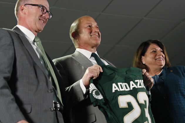 Steve Addazio, center, holds up a jersey during an announcement that he has been hired as the new head football coach at Colorado State University at a news conference at the school Thursday, Dec. 12, 2019, in Fort Collins, Colo. Athletic director Joe Parker, left, and President Joyce McConnell look on. (AP Photo/David Zalubowski)