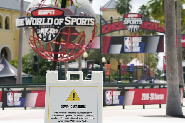 A COVID-19 warning is posted outside basketball arenas at ESPN Wide World of Sports Complex Wednesday, July 29, 2020, in Orlando, Fla. NBA games will resume Thursday. (AP Photo/Ashley Landis)