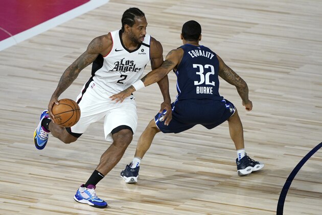 Los Angeles Clippers' Kawhi Leonard (2) drives around Dallas Mavericks' Trey Burke (32) during the first half of an NBA basketball game Thursday, Aug. 6, 2020 in Lake Buena Vista, Fla. (AP Photo/Ashley Landis, Pool)