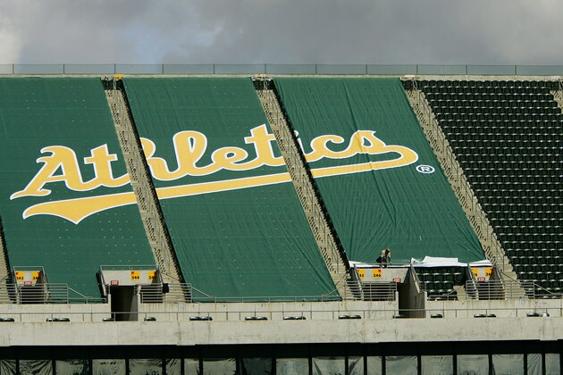 **  ADVANCE FOR WEEKEND EDITIONS, MARCH 18-19 ** Workers affix a green tarp over upper deck seats at McAfee Coliseum Wednesday, March 15, 2006, in Oakland, Calif. By the time the Oakland Athletics open their season against the New York Yankees next month, the team will have strung a tarpaulin over 10,000 of the most unattractive upper-deck seats, reducing McAfee Coliseum to one of the smallest in pro baseball. Counterintuitive as it may sound, the A's, who have struggled with low attendance, hope the removal of the stadium's entire third deck will boost season ticket sales and generate renewed fan loyalty. (AP Photo/Ben Margot)