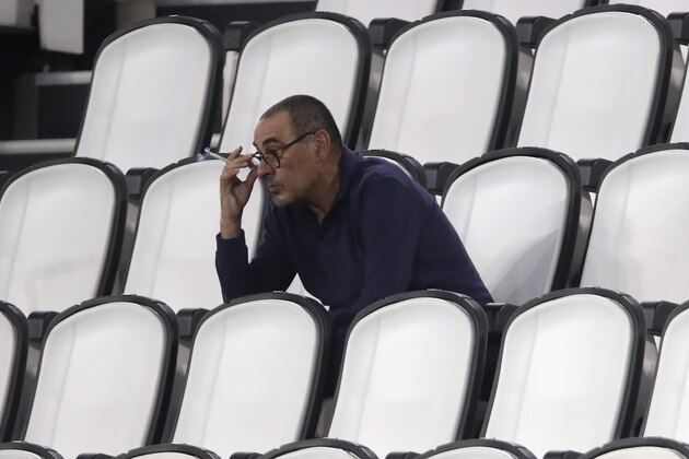 FILE - In this  Saturday, Aug. 1, 2020 filer, Juventus' head coach Maurizio Sarri smokes during a Serie A soccer match between Juventus and Roma, at the Allianz stadium in Turin, Italy. Cristiano Ronaldo scored twice but could not prevent Juventus from going out of the Champions League despite a 2-1 victory over Lyon in its rearranged second-leg match Friday. The French team progressed to the quarterfinals on away goals after a 2-2 draw on aggregate. (AP Photo/Luca Bruno, File)