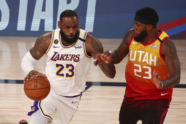 Los Angeles Lakers forward LeBron James, left, dribbles against Utah Jazz forward Royce O'Neale, right, during the first half of an NBA basketball game Monday, Aug. 3, 2020, in Lake Buena Vista, Fla. (Kim Klement/Pool Photo via AP)