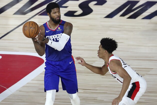 Los Angeles Clippers guard Paul George (13) looks to pass as Portland Trail Blazers guard Anfernee Simons (1) defends during the first half of an NBA basketball game Saturday, Aug. 8, 2020, in Lake Buena Vista, Fla. (Kim Klement/Pool Photo via AP) Los Angeles Clippers guard Paul George (13) looks to pass as Portland Trail Blazers guard Anfernee Simons (1) defends during the first half of an NBA basketball game Saturday, Aug. 8, 2020, in Lake Buena Vista, Fla. (Kim Klement/Pool Photo via AP)