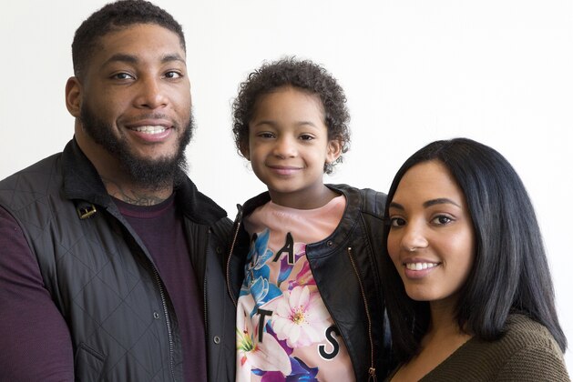FILE - In this April 12, 2016, file photo, Devon Still and his fiancee, Asha Joyce, pose with their daughter, Leah, then 5, in New York. Leah was diagnosed in 2014 with cancer and became an inspiration to millions as her football-playing father shared details of her brave fight. She was given a prognosis of just over 50 percent to survive stage 4 neuroblastoma. Leah is now a healthy 8-year-old girl in third grade who lives in Houston. Devon Still has become an author, motivational speaker, and an inspiration--especially to strangers suffering like his family did. (AP Photo/Mark Lennihan, File)