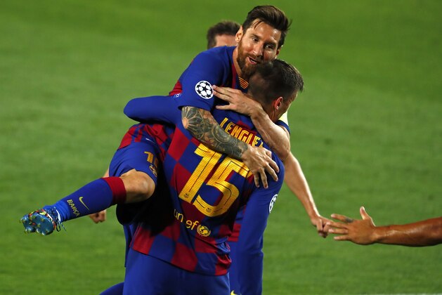 Barcelona's Clement Lenglet is embraced by Barcelona's Lionel Messi after scoring the opening goal during the Champions League round of 16, second leg soccer match between Barcelona and Napoli at the Camp Nou Stadium in Barcelona, Spain, Saturday, Aug. 8, 2020. (AP Photo/Joan Monfort)
