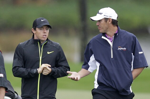 Rory McIlroy, of Northern Ireland, left, listens to Brooks Koepka at they walk to the clubhouse during a rain delay during the second round of the Honda Classic golf tournament, Friday, Feb. 27, 2015 in Palm Beach Gardens, Fla. (AP Photo/Luis M. Alvarez)