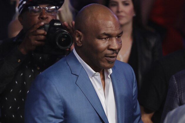 Former boxer Mike Tyson, center, attends a super welterweight boxing match between Floyd Mayweather Jr. and Conor McGregor on Saturday, Aug. 26, 2017, in Las Vegas. (AP Photo/Isaac Brekken)