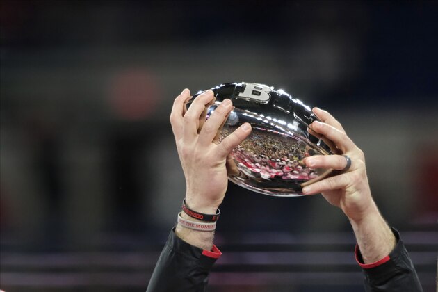Ohio State coach Ryan Day holds the trophy following the team's 34-21 win over Wisconsin in the Big Ten championship NCAA college football game, early Sunday, Dec. 8, 2019, in Indianapolis. (AP Photo/AJ Mast)
