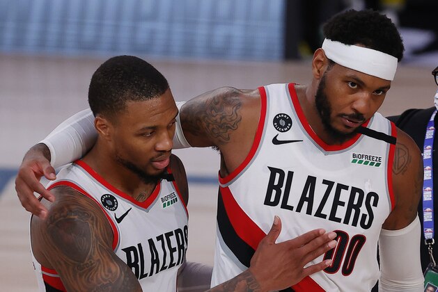 Portland Trail Blazers' Carmelo Anthony, right, and Damian Lillard celebrate the team's win over the Philadelphia 76ers in an NBA basketball game Sunday, Aug. 9, 2020, in Lake Buena Vista, Fla. (Kevin C. Cox/Pool Photo via AP)