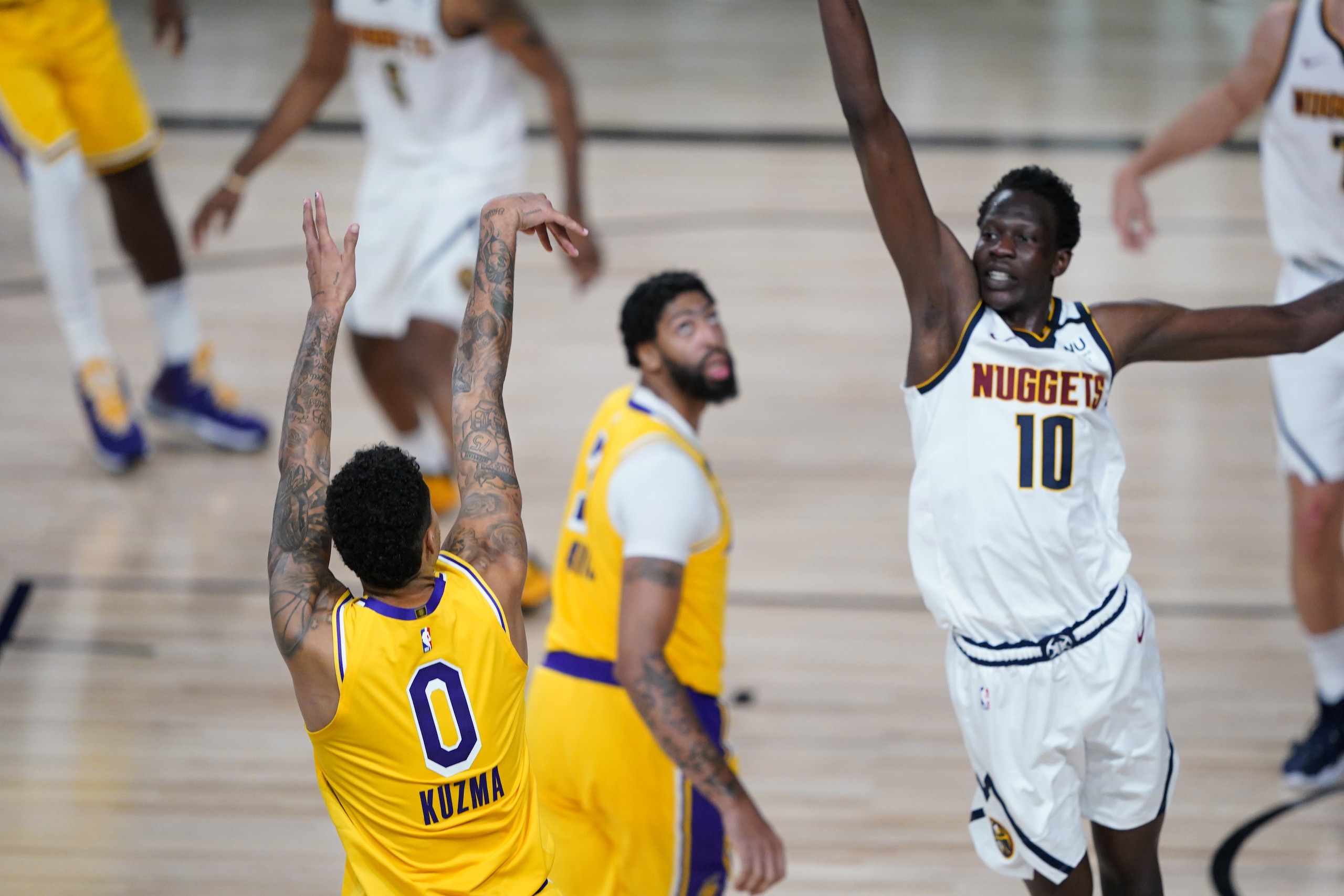 Los Angeles Lakers' Kyle Kuzma (0) follows through on his game-winning 3-pointer over Denver Nuggets' Bol Bol (10) during the second half of an NBA basketball game Monday, Aug. 10, 2020, in Lake Buena Vista, Fla. The Lakers won 124-121. (AP Photo/Ashley Landis, Pool)